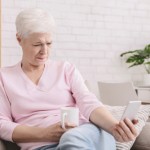 Woman squinting and holding phone far from eyes